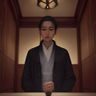 数据编辑陈屿在办公室白板前，身后贴着各平台内容更新频率的手写图表